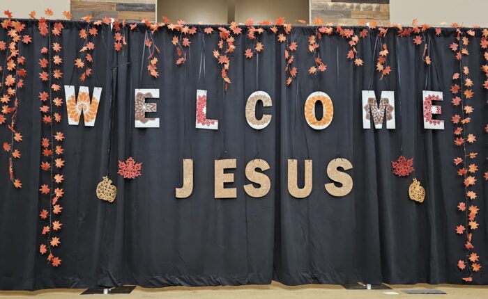 Fall-themed decor with stenciled letters reading "Welcome Jesus"